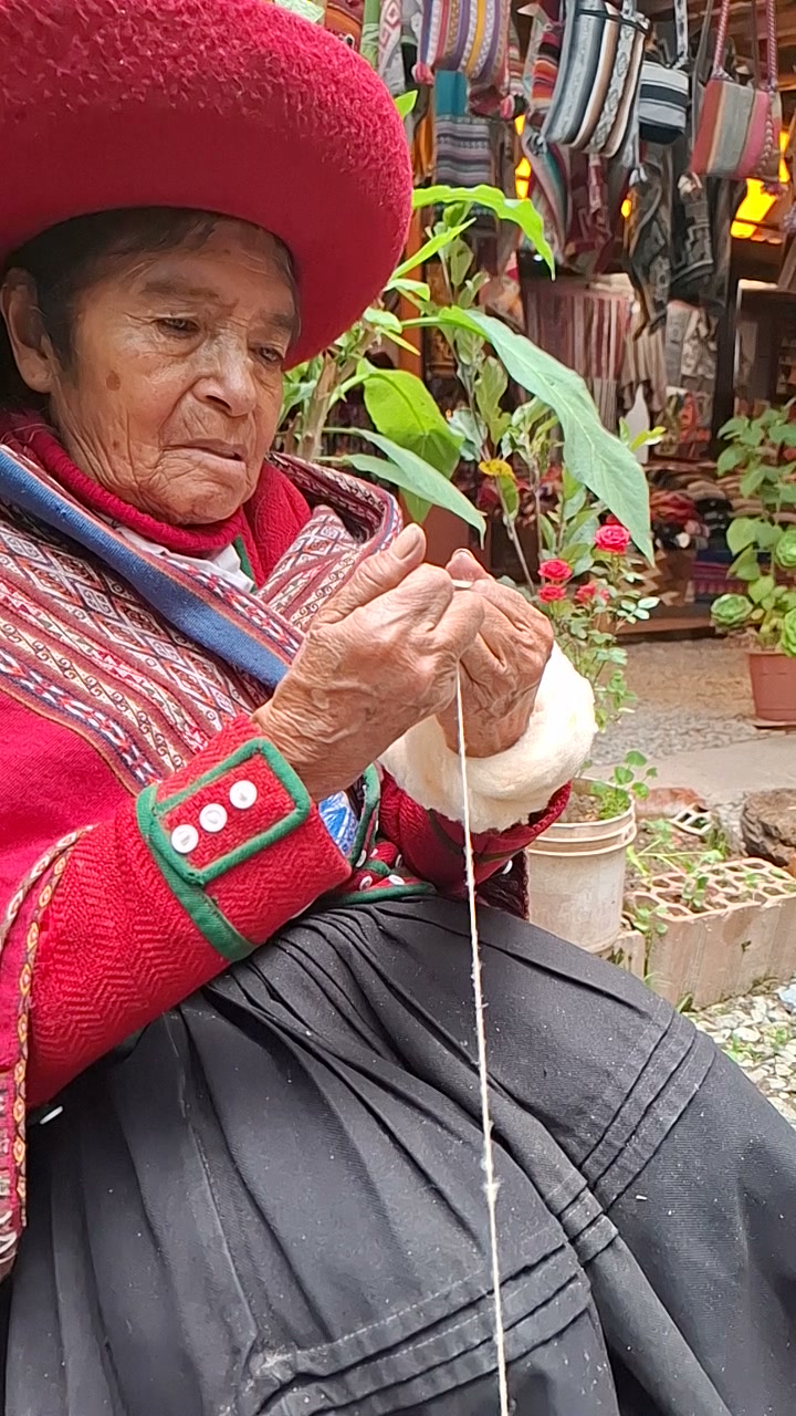 Una mujer hilando a mano en el archivo de la marca