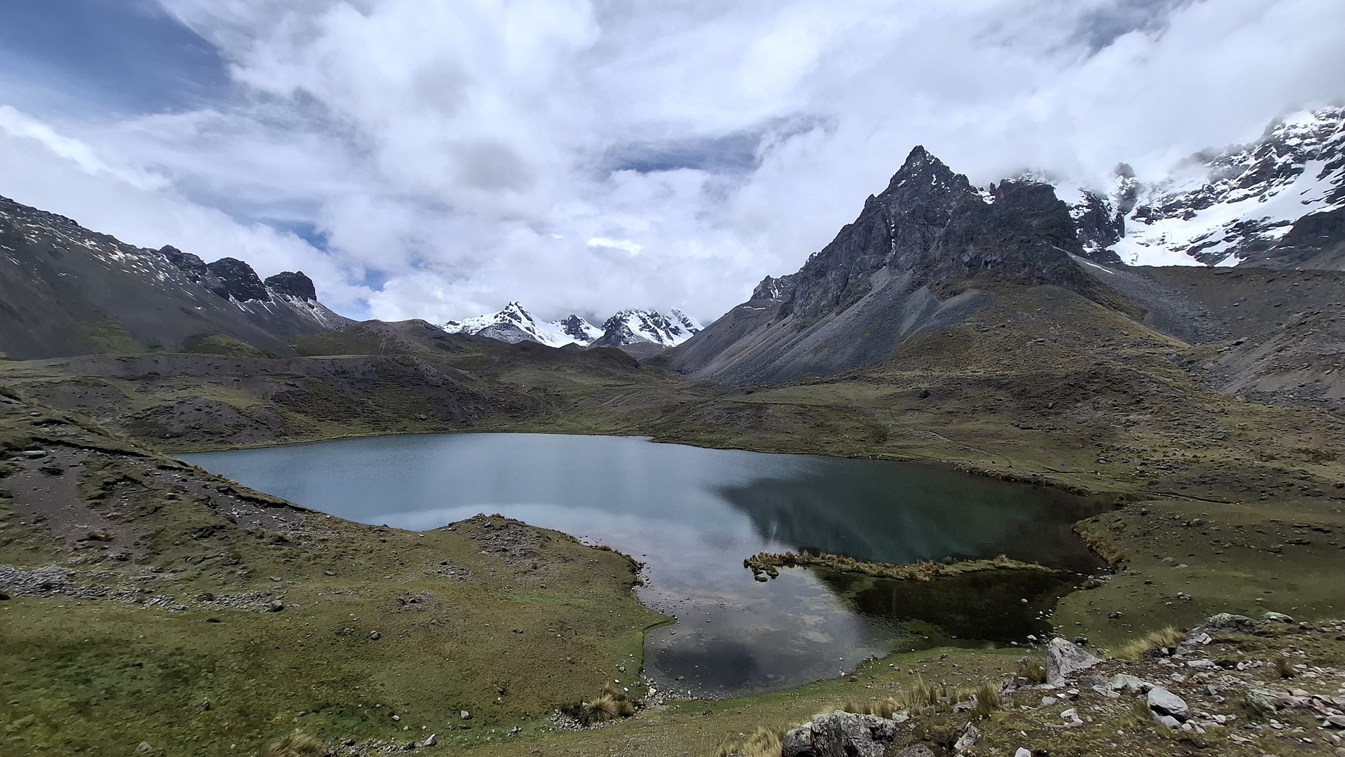Laguna rodeada por montañas y nubes